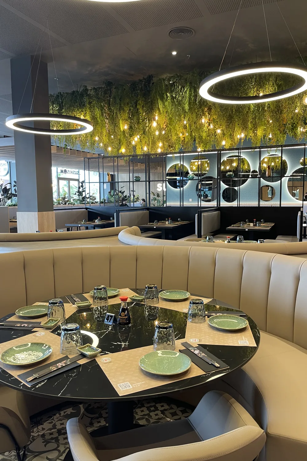 Mesa con vajilla verde frente al jardín vertical — Sushisom Viladecans Style Outlet