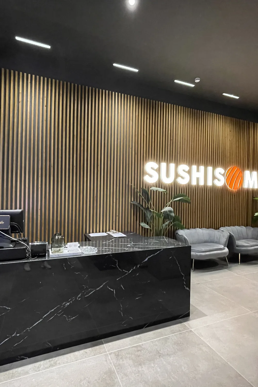 Recepción de mármol negro con el logo — Sushisom Viladecans Style Outlet